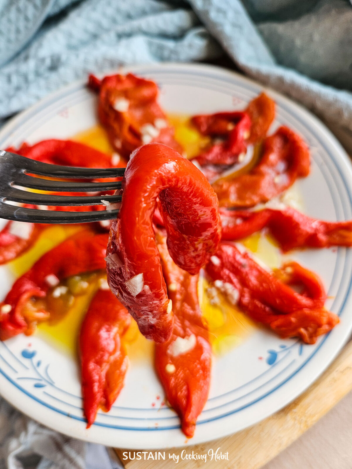 A fork holding a roasted red pepper antipasto.