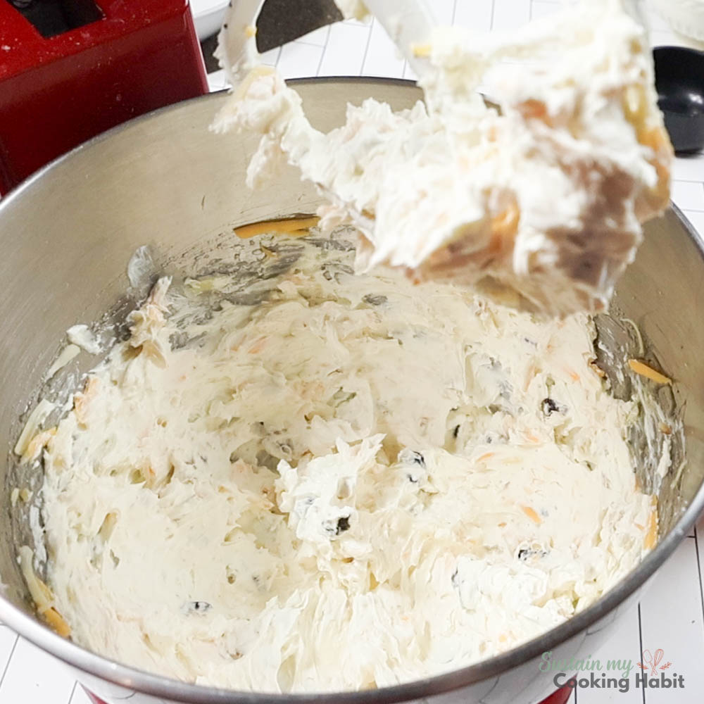 Adding cranberries and walnuts to the cheese mixture. 