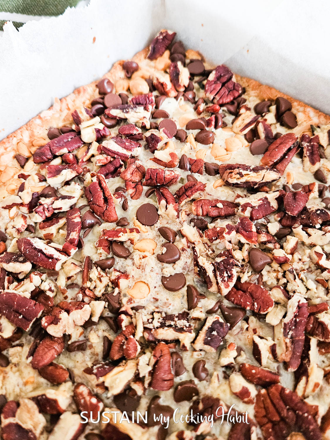 Close up of baked ingredients in an ultimate seven layer bar.