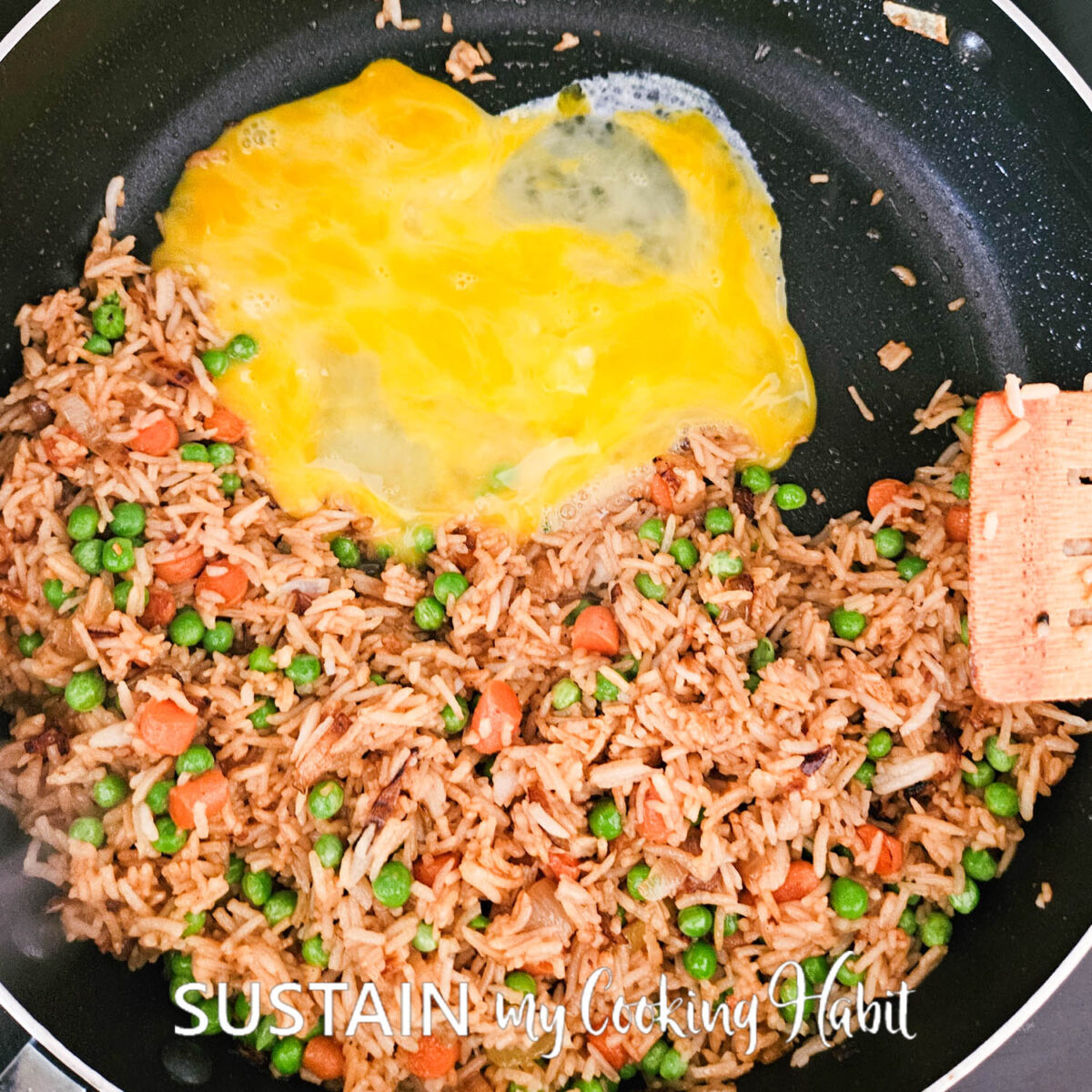 Pouring beaten eggs next to rice.