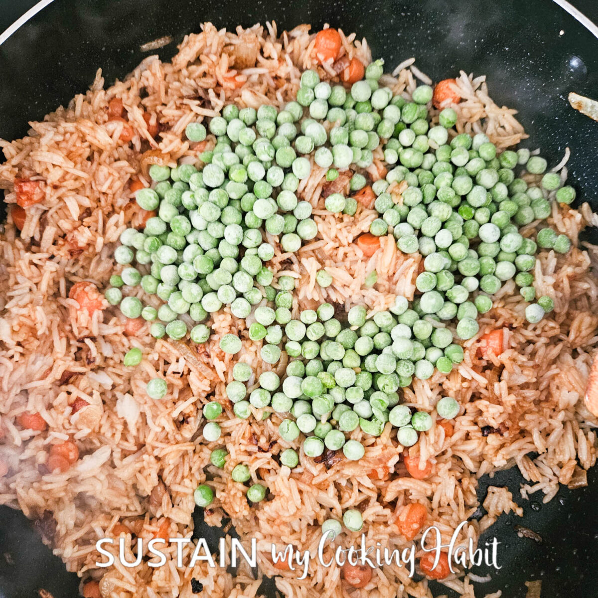 Adding frozen peas to pan with rice. 