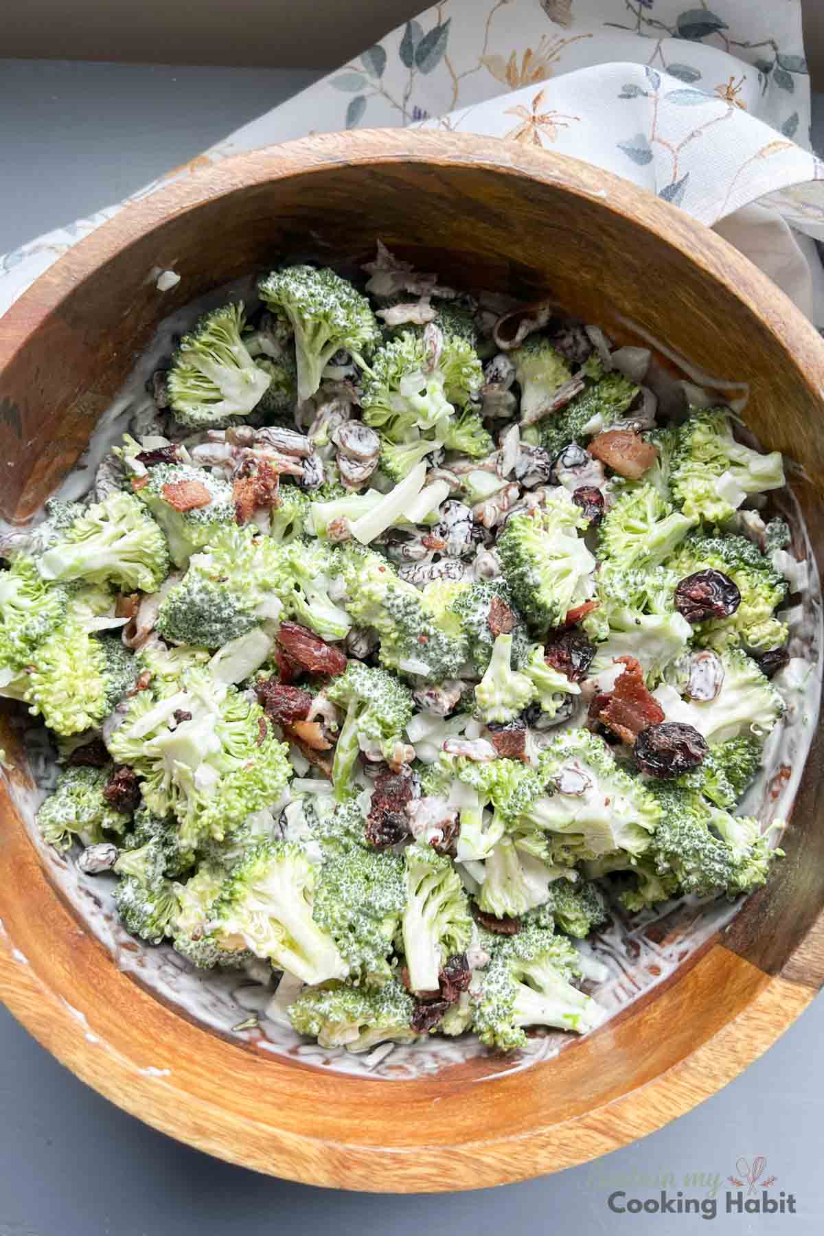 Mixing dressing into broccoli and craisin salad.