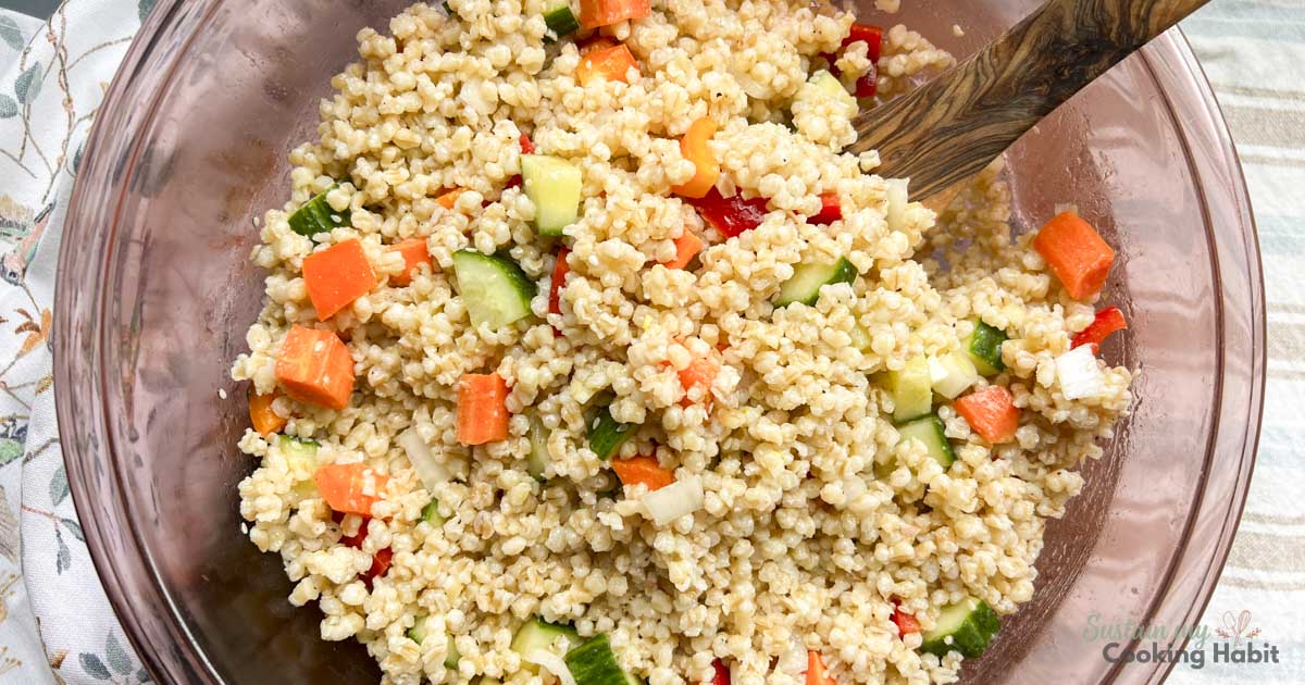 Cold barley salad with vegetables in a bowl.