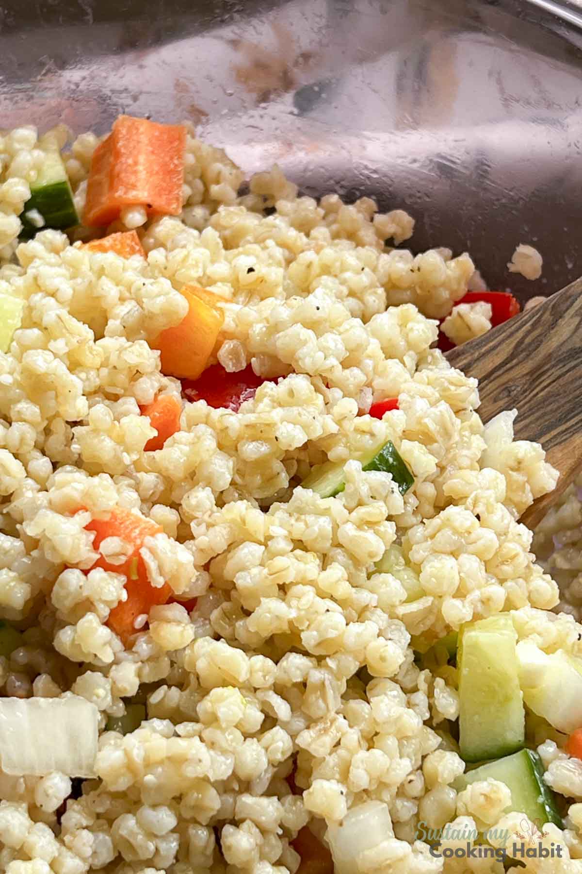 Close up of cold barley salad with vegetables.