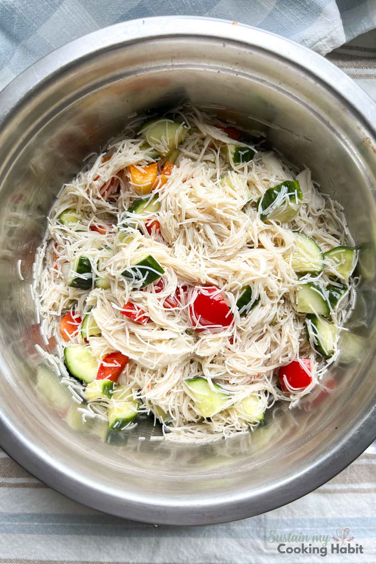Rice noodle salad with vegetables in a silver bowl.