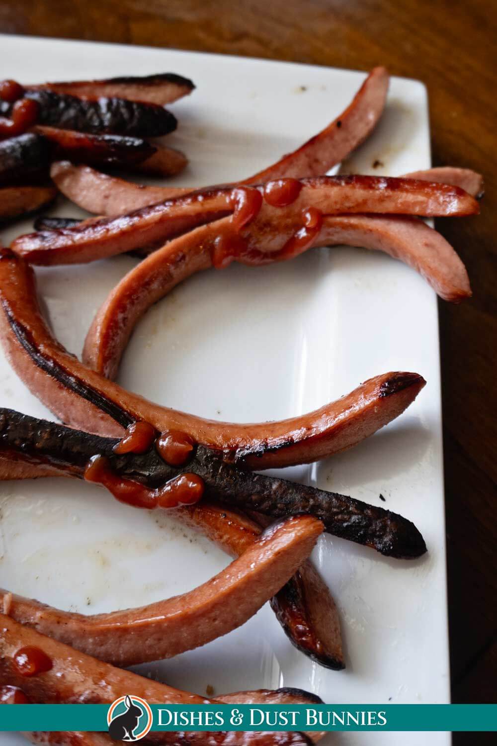 plate full of campfire grilled hot dogs cut on both ends