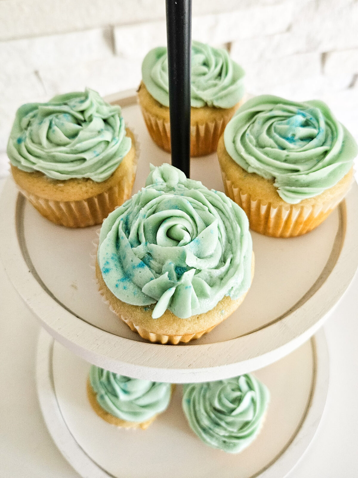 Frosted cupcakes made from scratch set on a tiered tray.
