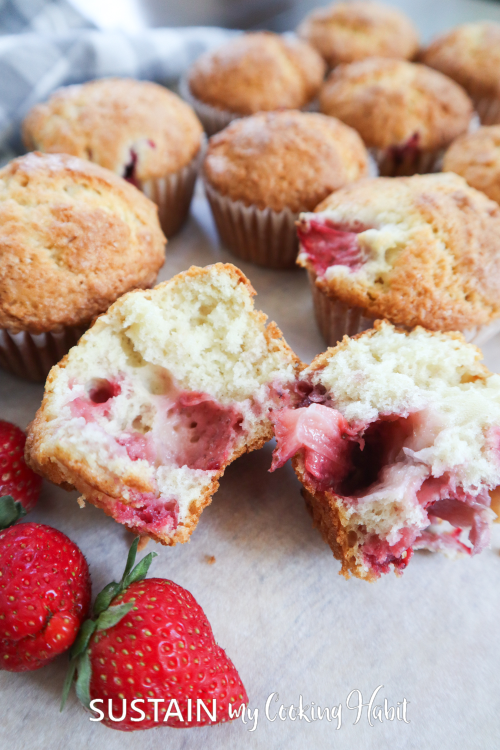 Strawberry muffin cut in half showing berries inside.